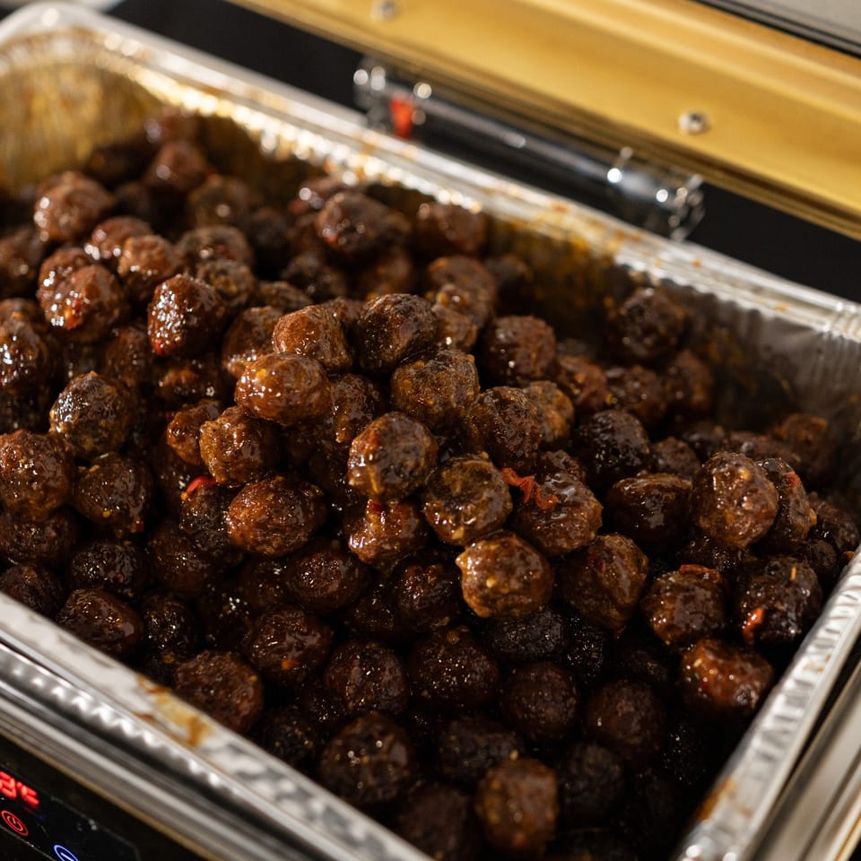 Glazed meatballs in a catering chafing tray